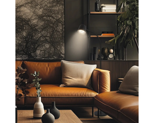 Wohnzimmer mit Ledersofa, Stehlampe und Bücherregal für ein gemütliches Ambiente