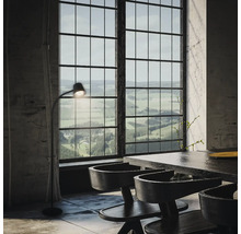 Interieur mit Esstisch, Stühlen und Stehlampe vor großem Fenster mit Landschaftsblick