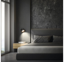 Schlafzimmer mit Bett, Nachttisch und Wandleuchte