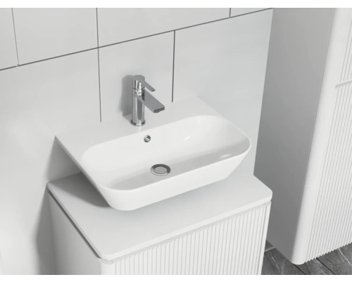 Lavabo de salle de bains moderne avec robinet sur un meuble-lavabo à structure rainurée.