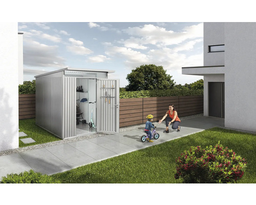 Abri de jardin en métal avec porte ouverte, enfant sur un vélo et femme dans le jardin