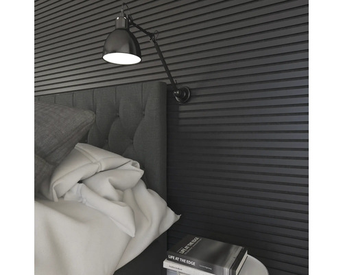 Gros plan d''une chambre à coucher avec des panneaux muraux, une lampe de chevet et une tête de lit rembourrée