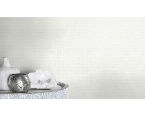 Éléments décoratifs sur une table devant un mur avec un motif triangulaire