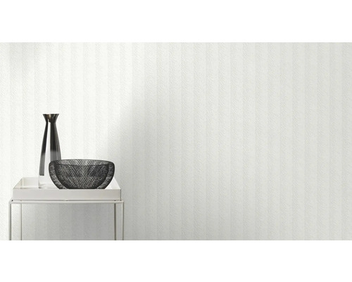 Mur clair avec papier peint, avec un vase et un bol sur une table