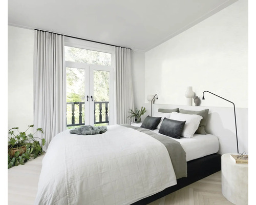 Chambre lumineuse avec lit, table de chevet, lampe, rideaux et plante d''intérieur