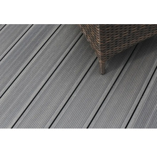 Gros plan sur des lames de terrasse en bois gris avec un meuble