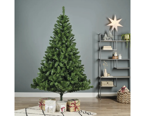 Sapin de Noël artificiel vert avec des cadeaux dans le salon.