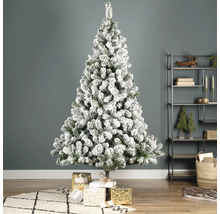 Sapin de Noël décoré et enneigé avec des cadeaux dans le salon.