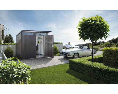 Abri de jardin en métal avec portes ouvertes, étagères et nettoyeur haute pression à côté d''un homme qui nettoie une voiture