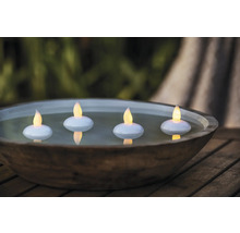 Bol décoratif avec quatre bougies LED flottantes sur une table en bois