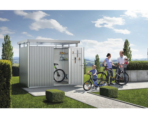 Famille avec vélos devant un garage à vélos dans le jardin