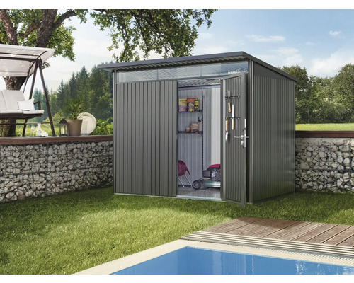 Abri de jardin en métal avec portes ouvertes et outils de jardinage sur la pelouse