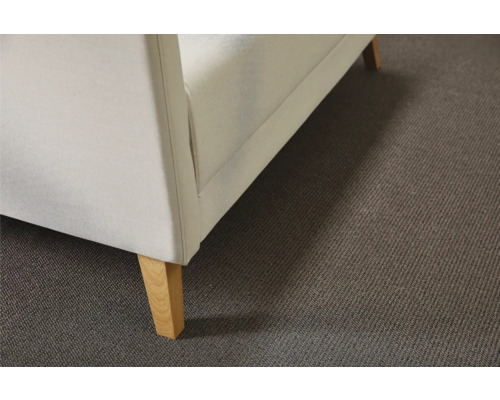 Gros plan d'un canapé avec revêtement en tissu et pieds en bois