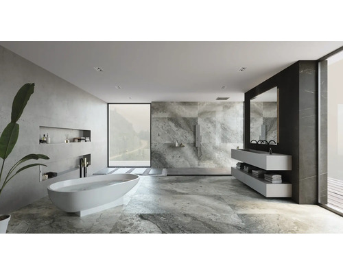 Salle de bain lumineuse avec baignoire, lavabo, miroir et carreaux gris.