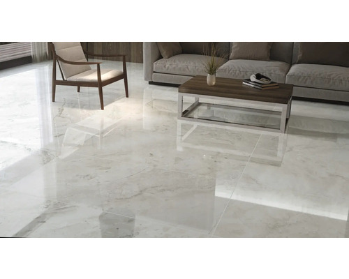 Salon lumineux avec carrelage brillant, canapé, fauteuil et table