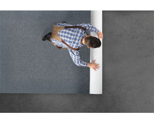 Mann rollt Teppich aus.