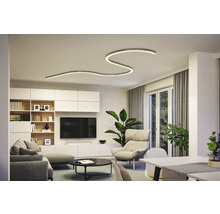 Modernes Wohnzimmer mit geschwungener Deckenleuchte, Sofa, Sessel und TV-Wand.