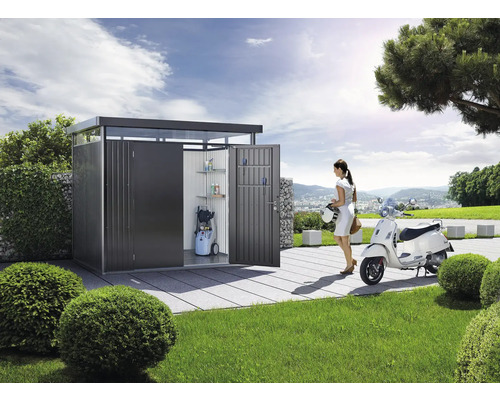 Armoire à outils moderne en métal avec étagères, nettoyeur haute pression et une femme avec un scooter dans le jardin.