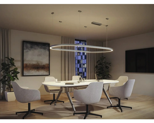 Besprechungsraum mit ovaler LED-Pendelleuchte über einem ovalen Tisch