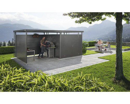 Salon de jardin moderne avec espace barbecue et coin salon sur une terrasse pavée