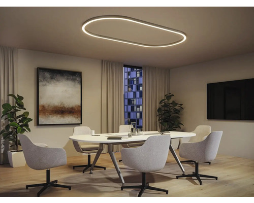 Modernes Besprechungszimmer mit ovaler Deckenleuchte, weißem Tisch und grauen Stühlen.