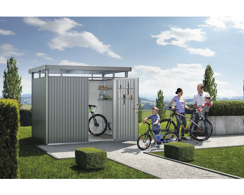 Famille devant un abri à vélos avec des vélos et des accessoires de jardin