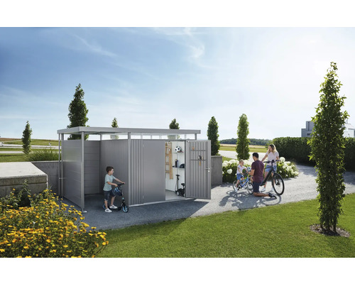 Famille avec vélos et trottinettes devant un abri de jardin.