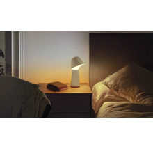 Table de chevet avec lampe et livres dans une chambre