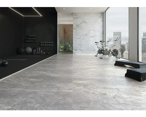 Fitnessstudio mit Sportgeräten und grauen Bodenfliesen in Steinoptik