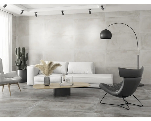 Salon lumineux avec canapé, fauteuil et lampadaire sur carrelage