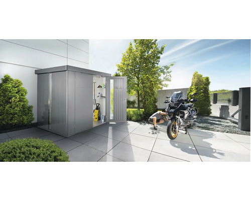 Gartenszene mit Metallgartenhaus, Motorrad und Person bei Reparaturarbeiten