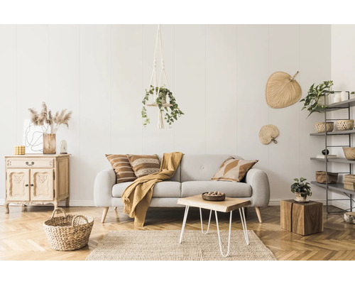 Salon avec canapé, table en bois et éléments décoratifs dans une ambiance lumineuse et conviviale.