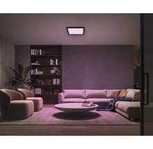 Wohnzimmer mit Sofa, Sesseln, Bücherregal und Deckenleuchte