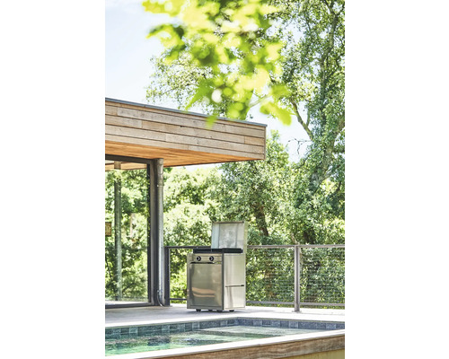 Grill à gaz en acier inoxydable sur une terrasse avec piscine