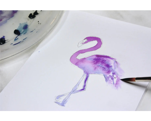 Aquarellmalerei eines Flamingos auf Papier mit Pinsel und Farbpalette