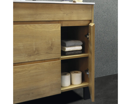 Meuble sous-vasque avec porte ouverte, serviettes et papier toilette