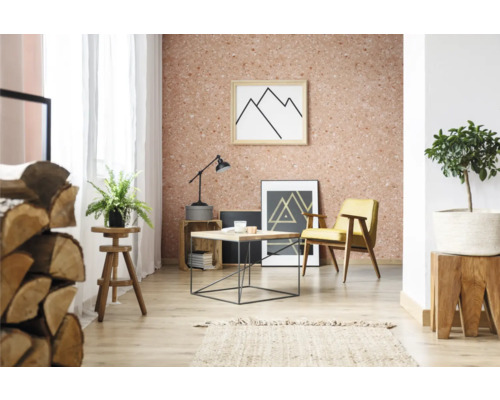 Salon avec papier peint en liège, fauteuil, table et décorations.