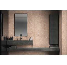 Salle de bains moderne avec carrelage terrazzo sur les murs et le sol, meuble-lavabo avec miroir et serviettes