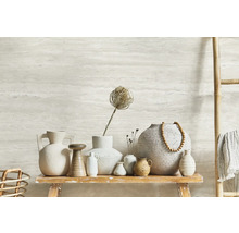 Dekorative Keramikvasen auf einem rustikalen Holztisch, ergänzt durch eine Bambusleiter mit Textilien und eine Wand mit horizontalem Muster.