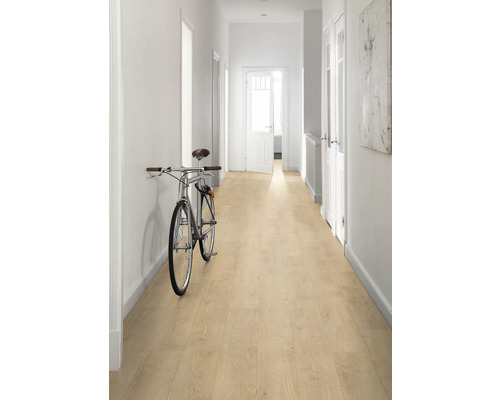 Couloir lumineux avec sol stratifié imitation bois et un vélo contre le mur