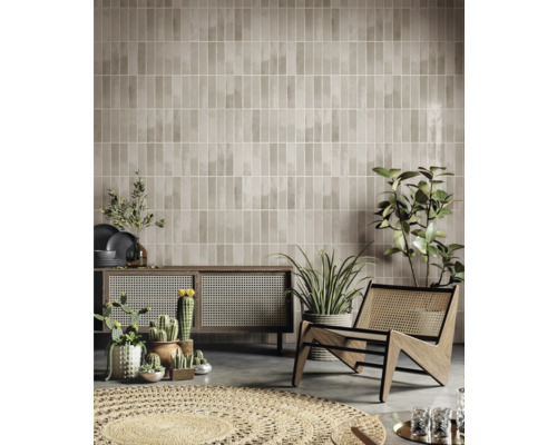 Wohnraum mit braunen Wandfliesen, Holzschrank, Sessel und Zimmerpflanzen