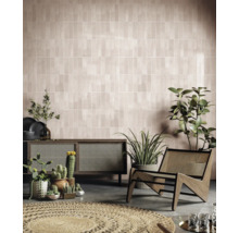 Salon avec mur carrelé, commode, fauteuil et plantes