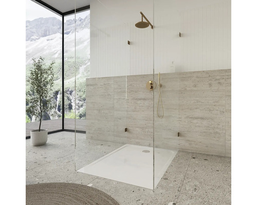 Douche à l''italienne avec pommeau de douche et robinet devant un mur carrelé