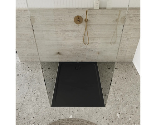 Douche plain-pied avec receveur noir et robinetterie dorée.