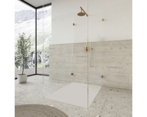 Begehbare Dusche mit Duschwanne und Armatur vor gefliester Wand