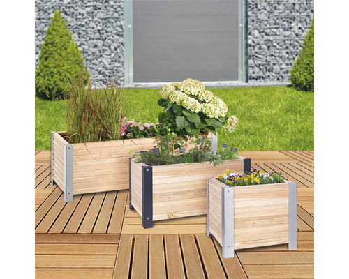 Drei Pflanzkästen aus Holz mit Pflanzen und Blumen auf einer Terrasse
