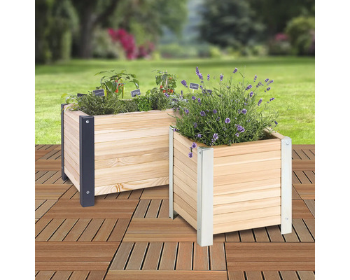 Deux jardinières en bois plantées avec des coins métalliques dans le jardin.