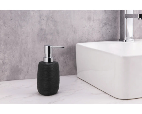 Schwarzer Seifenspender neben einem weißen Waschbecken