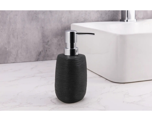 Schwarzer Seifenspender aus Keramik mit Pumpe aus Metall neben Waschbecken