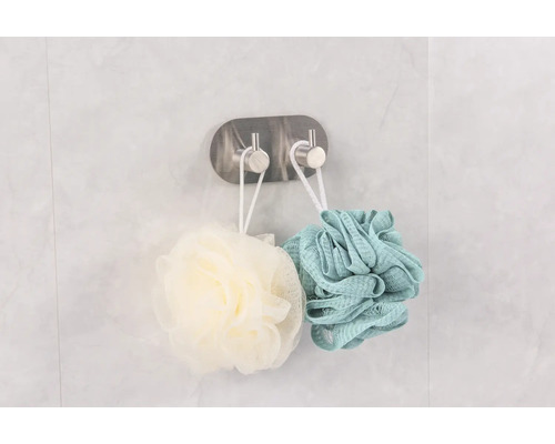 Deux éponges de douche suspendues à un crochet pour le rangement de la salle de bain.